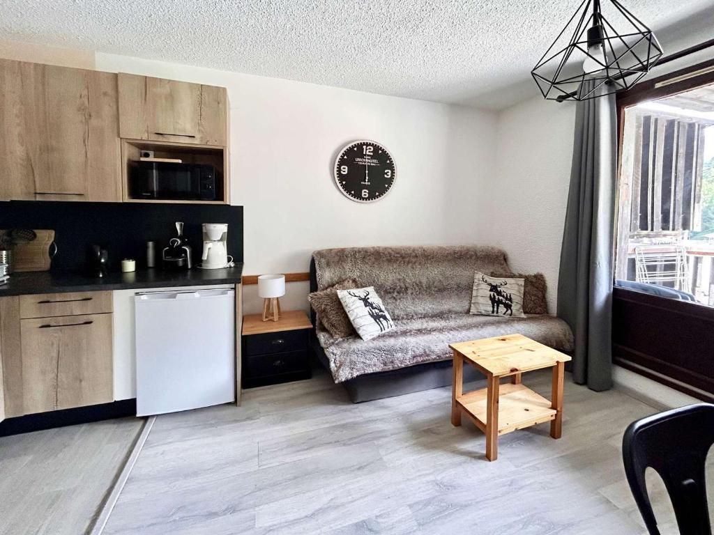 a living room with a couch and a table at Studio rénové cœur de station, skis aux pieds - FR-1-322-323 in Les Orres