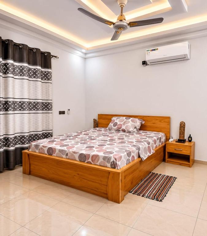 a bedroom with a bed and a ceiling fan at Grand Studio Meublé à Lomé in Komé