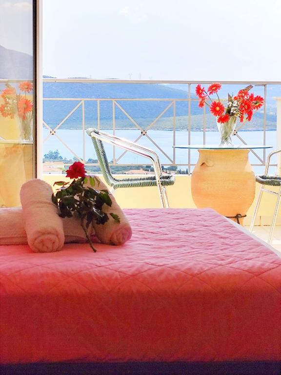 a teddy bear sitting on a bed with flowers on it at Villa Christine - Maisonettes with fireplace in Aliveri