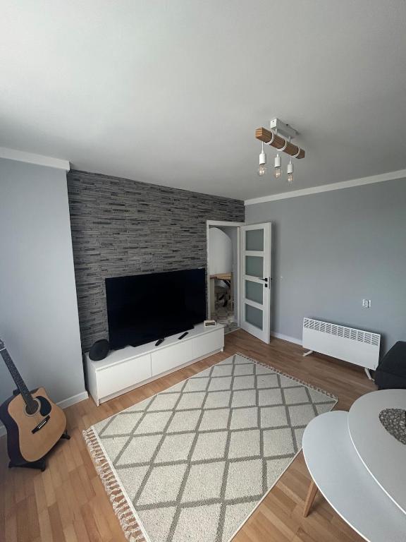 a living room with a flat screen tv on a brick wall at Pavels Cozy Nook in Smolyan