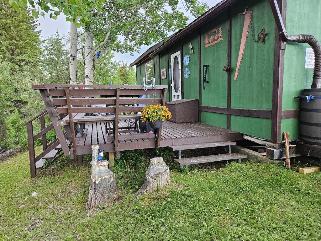 a green train car with a bench and flowers at Hidden Creek Cabin in Beaverlodge