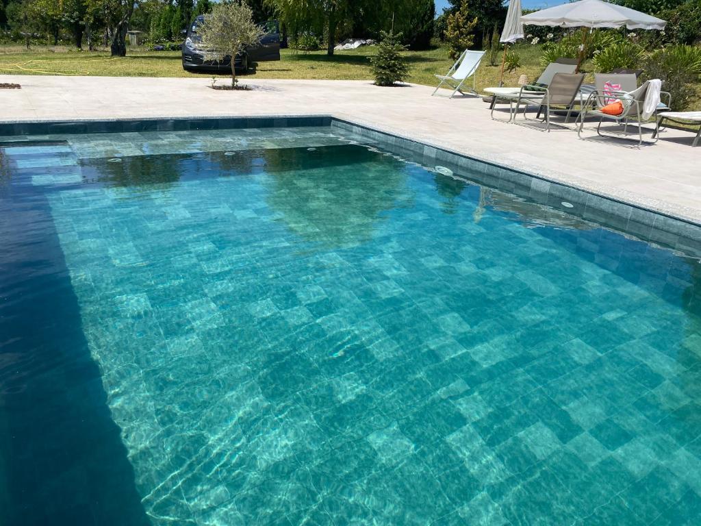 a large swimming pool with blue water at Quinta da Maínha - Charming Houses - com piscina privada in Braga