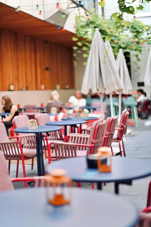a group of tables and chairs with umbrellas at ClapClap Hôtel Strasbourg in Strasbourg