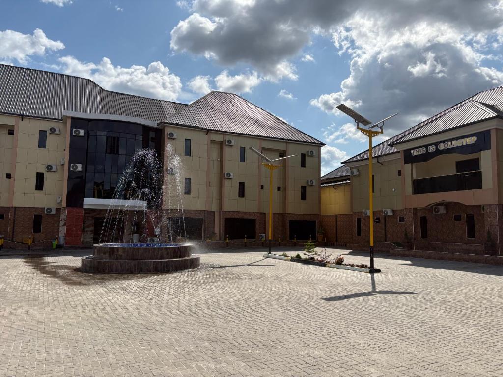 a courtyard with a fountain in front of a building at Goldstep hotel Okpaka in Warri