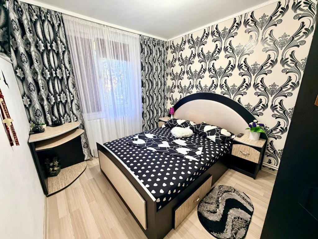 a bedroom with a bed and a black and white patterned wall at Apartament Arys 2 in Neptun