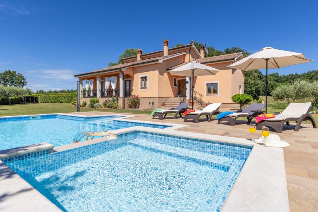 a swimming pool in front of a house at Villa Antonela in Radetići