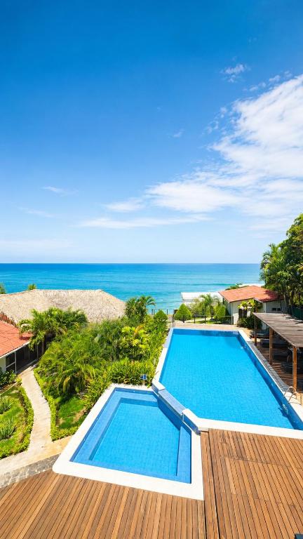 a pool on a deck with the ocean in the background at Laola Surf Residence in El Sunzal
