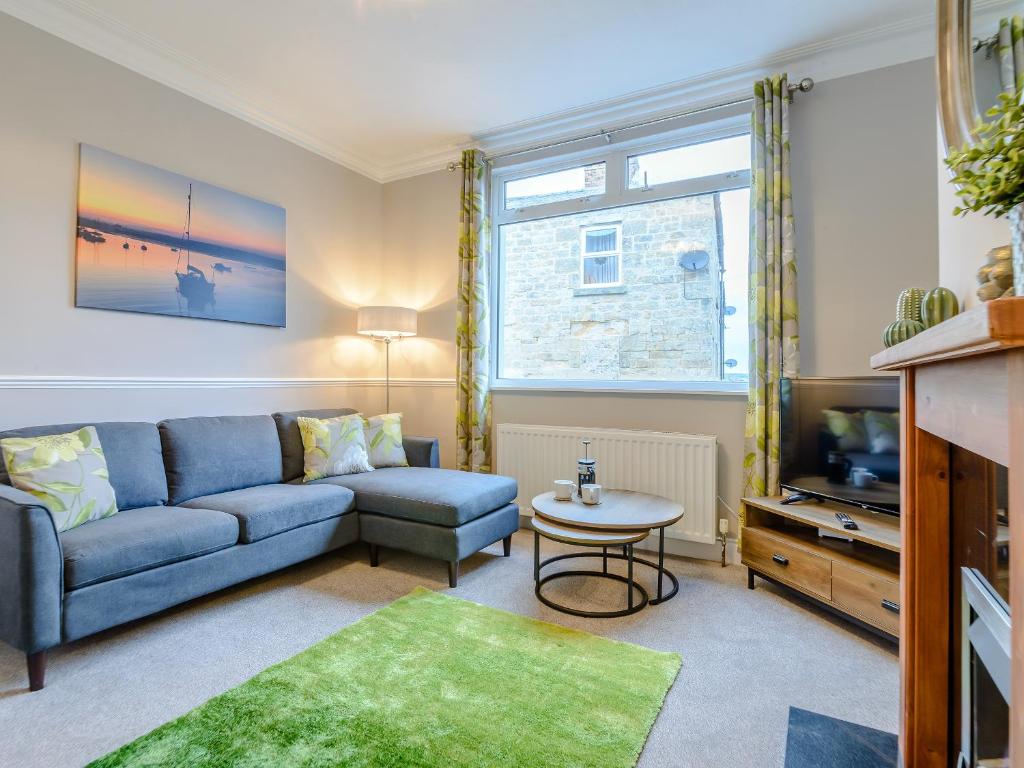 a living room with a blue couch and a tv at High Haven in Amble