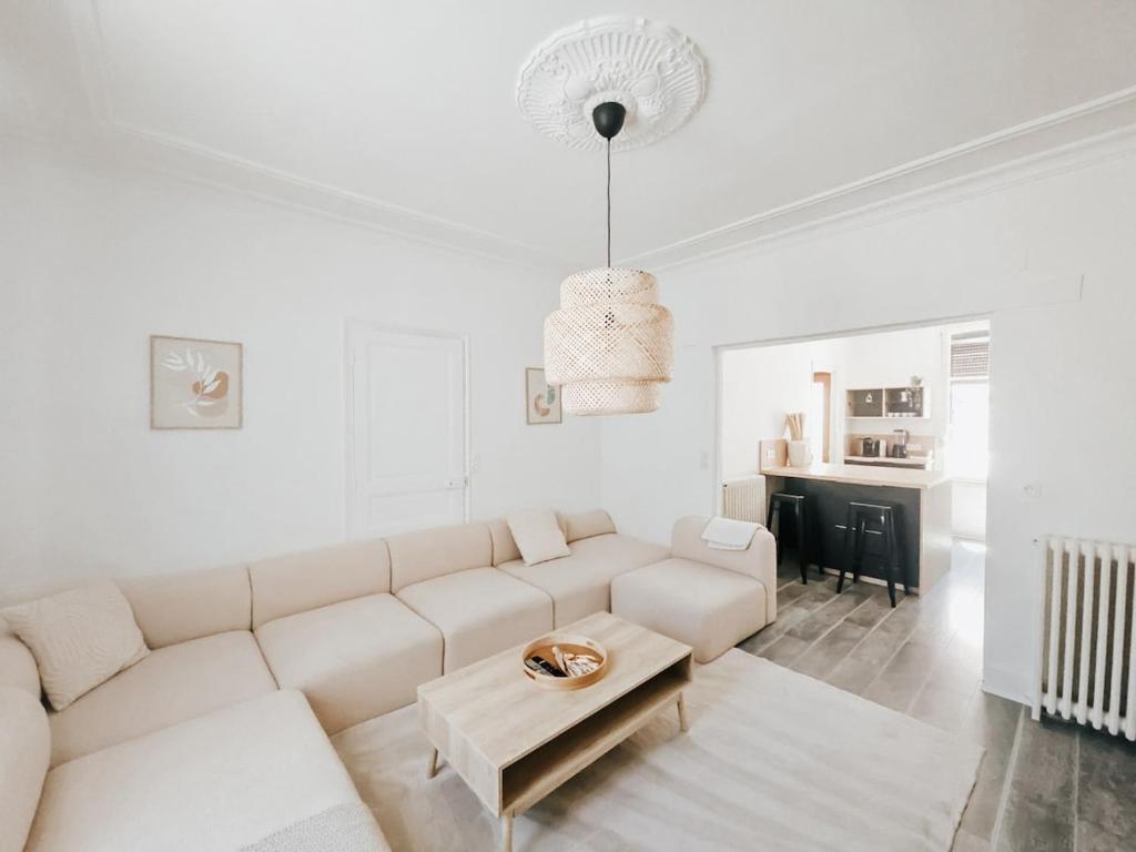 a white living room with a white couch and a table at Champagne getaway, spacious house in Épernay