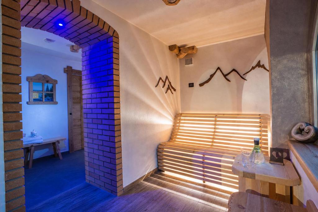 a room with a bench and a brick wall at Hotel Ristorante Milano in Vermiglio