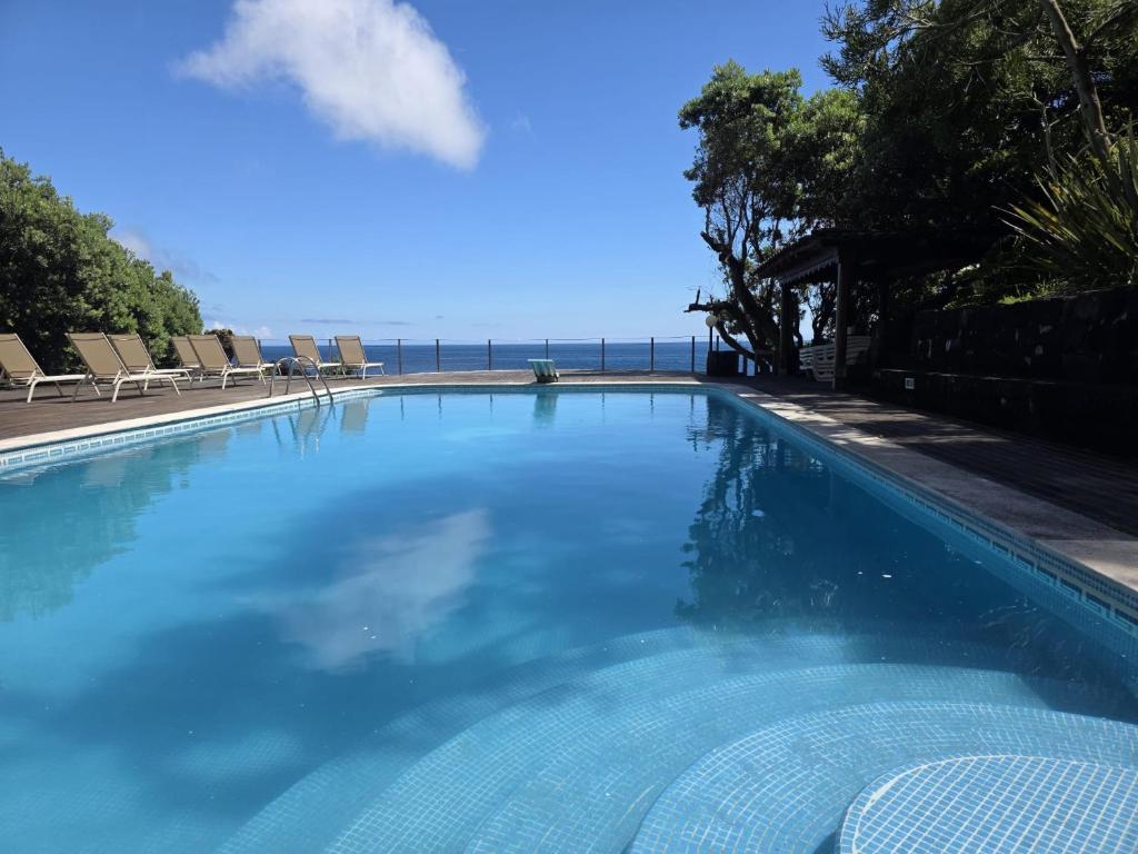 a swimming pool with a view of the ocean at Aldeia da Fonte Hotel in Lajes do Pico