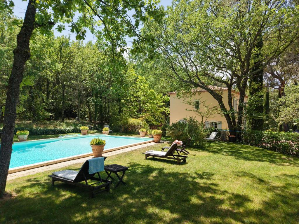 a person sitting in a chair next to a swimming pool at LS7-468 - Eicela in Saint-Antonin-sur-Bayons