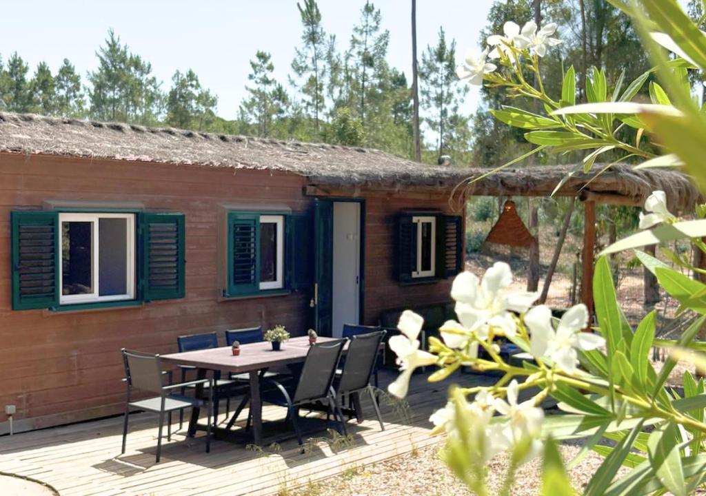a small house with a table and chairs on a deck at Casa Silvestre in Melides