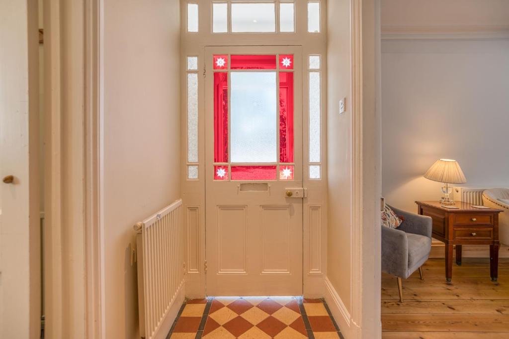 a hallway with a door with a window and a chair at Ty Mor in Tenby