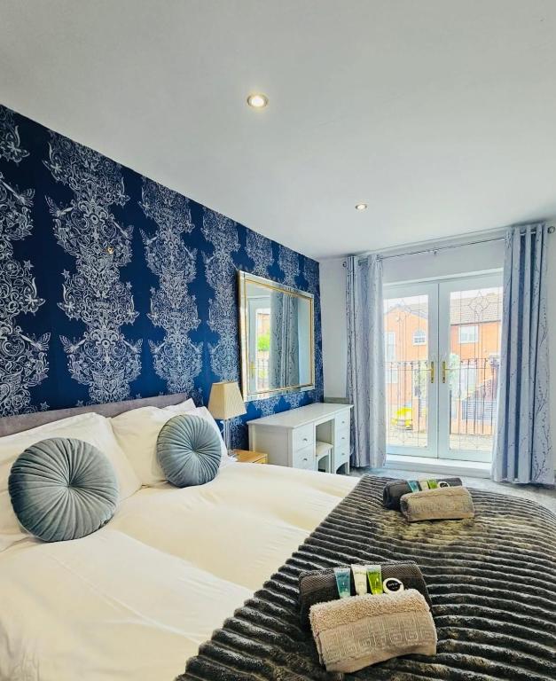 a bedroom with a large bed with two pillows on it at Luxury Home with Pool in Barnsley