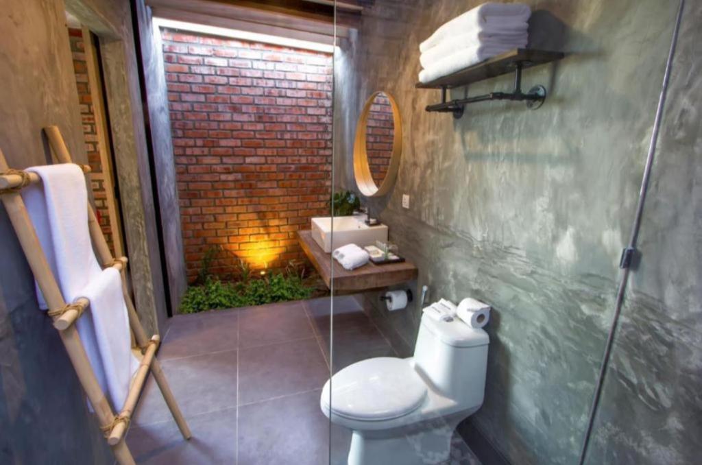 a bathroom with a toilet and a sink and a mirror at The Haira Varkala in Varkala