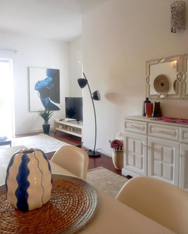 a living room with a table and chairs and a television at Garden Luz House in Lagos