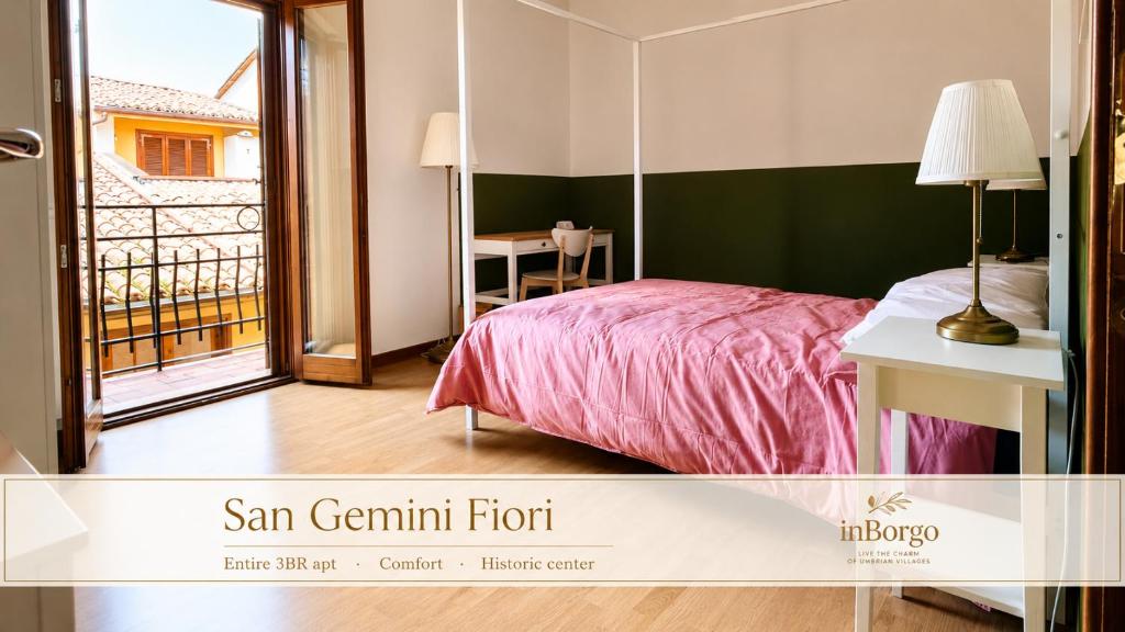 a bedroom with a bed and a table and a balcony at San Gemini Fiori - InBorgo in San Gemini