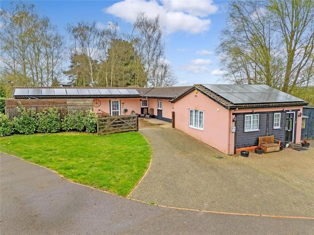 a house with a garage and a yard at The Stables in Great Horkesley
