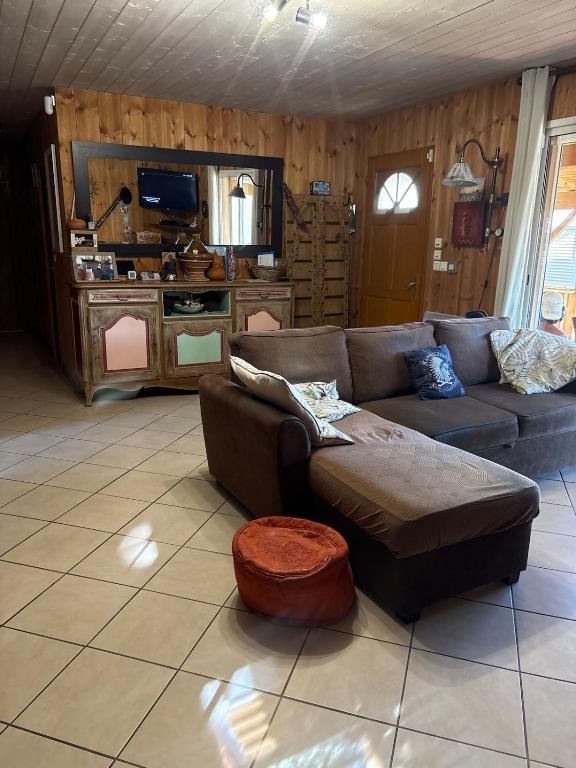 a living room with a couch and a tv at Villa Serena offrez vous une parenthese in Le Porge