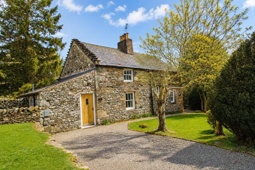 an old stone house with a yellow door at Red Squirrel Cottage, Hutton luxurious cottage in a rural setting 10 minutes to Ullswater 15 minutes to Keswick in Penruddock