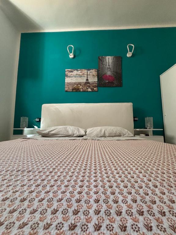 a bedroom with a large bed with a green wall at La Portella in Ischitella