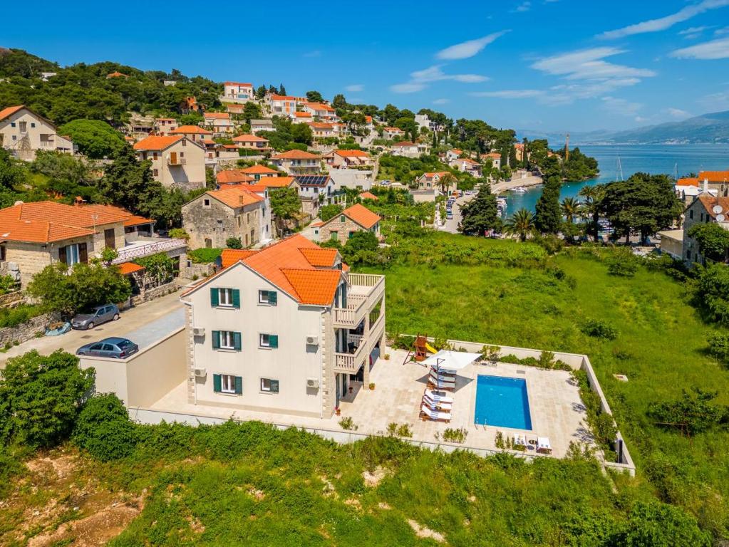 an aerial view of a house with a swimming pool at Villa Janie - Modern Pool Apartments Splitska in Splitska