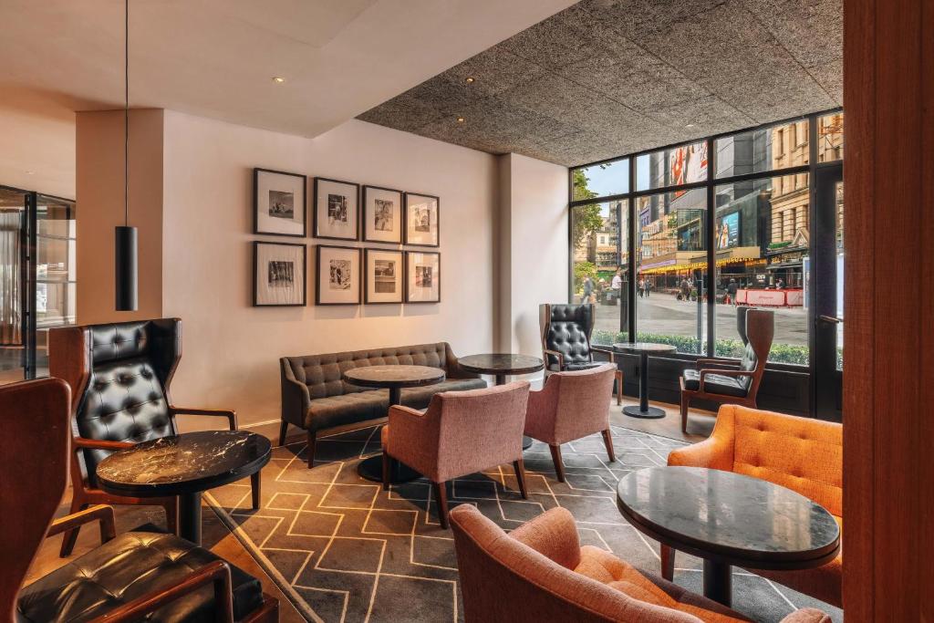 a lobby with tables and chairs and a window at Radisson Blu Hotel, London Leicester Square in London