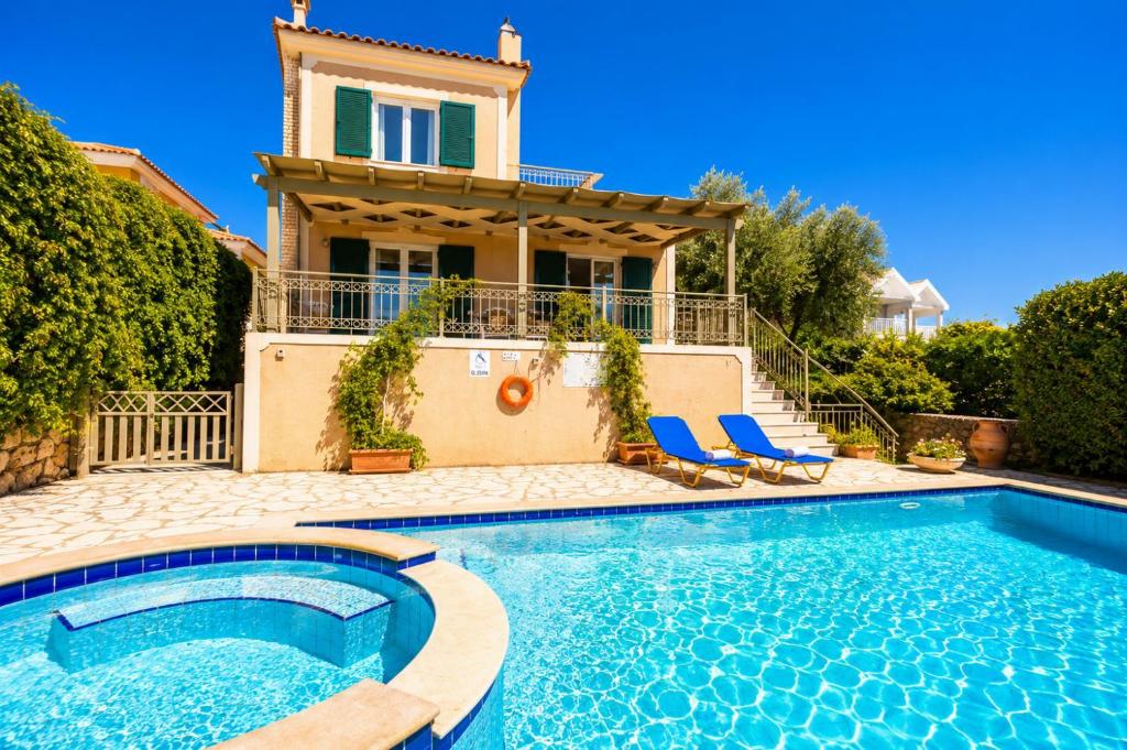 a villa with a swimming pool in front of a house at Villa Penelope Sea View in Argostoli