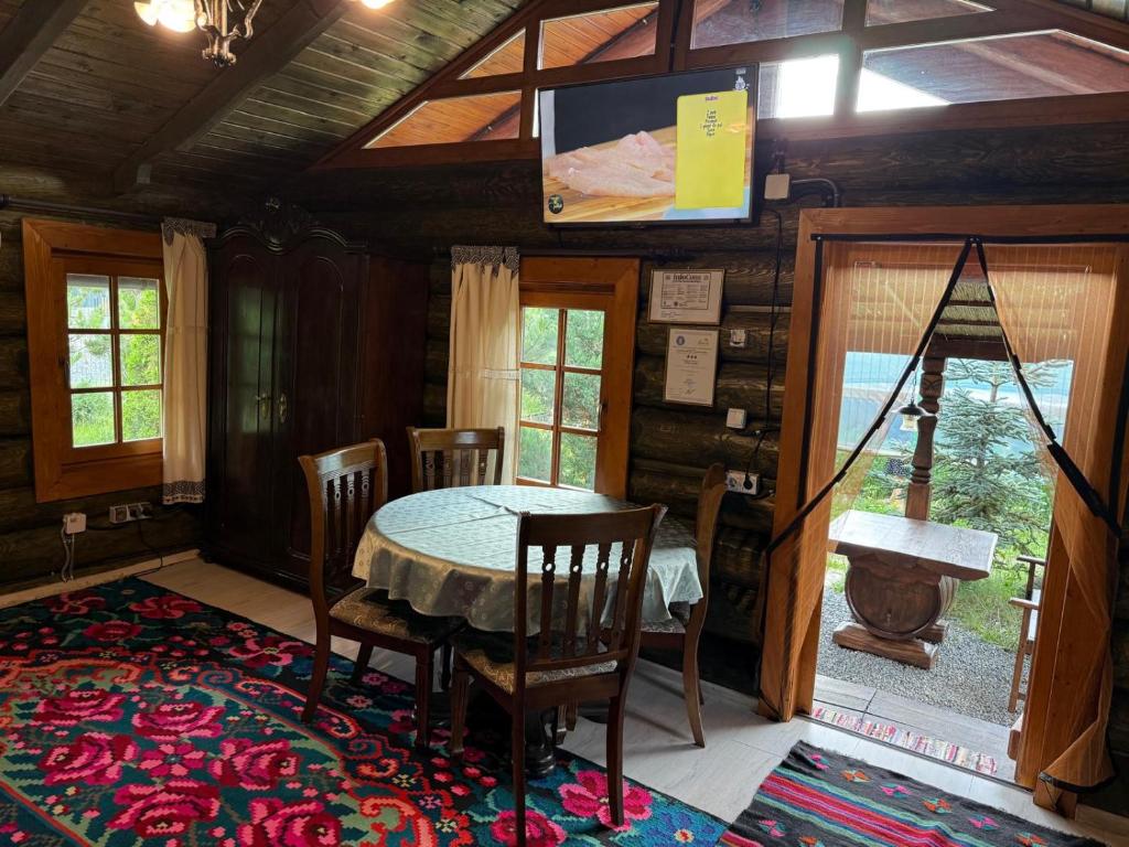 a dining room with a table and a tv on the wall at Cabana Vadim in Turda