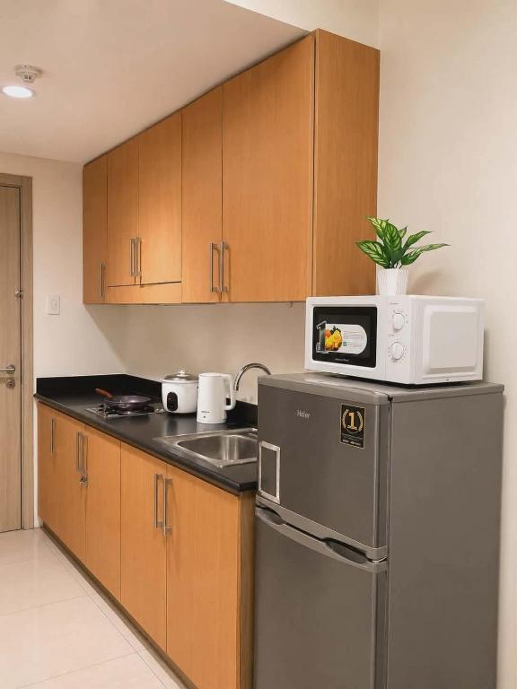 a kitchen with a microwave on top of a refrigerator at Shore 1 tower D Pasay City in Manila