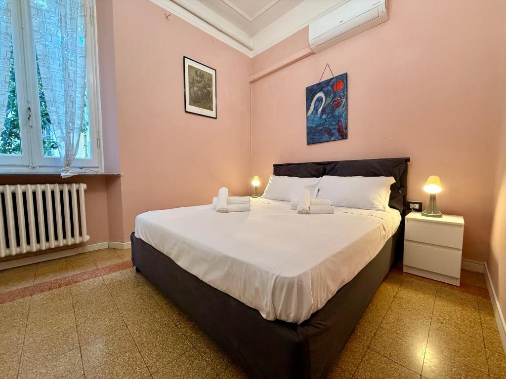 a bedroom with a large bed with white sheets at La Gardenia del ducato in Parma