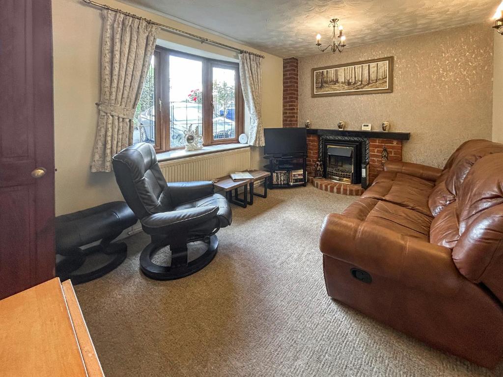 a living room with a couch and a chair at Bramble Grange in Derby