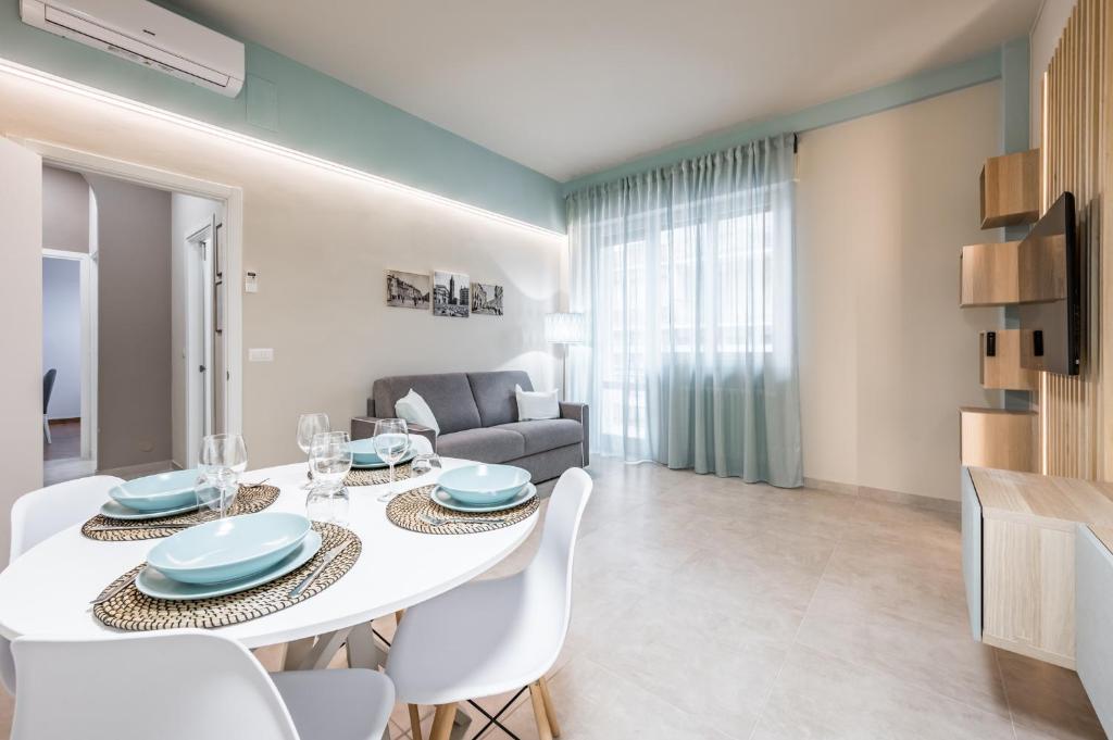 a dining room and living room with a white table and chairs at Casa Amelia - Elegant Suite [parcheggio gratuito] in Parma