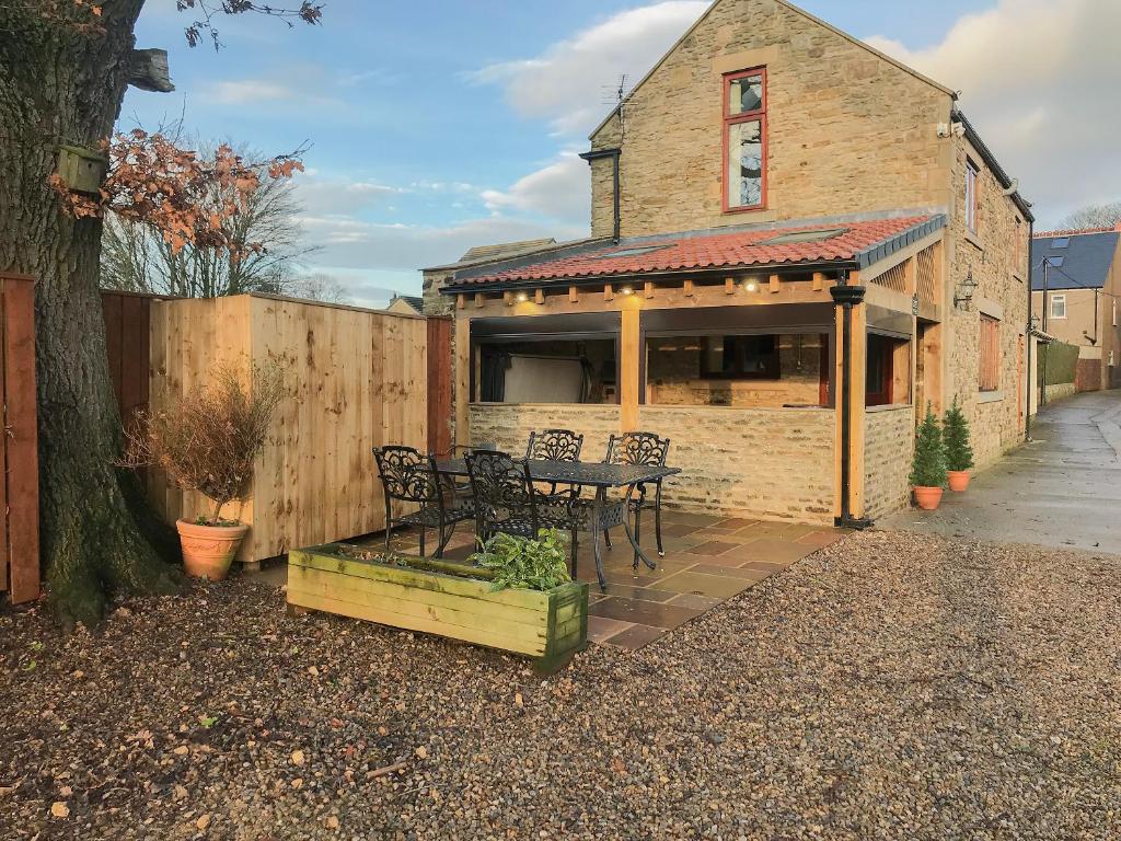a patio with a table and chairs in front of a building at Roslyn Cottage in Hamsterley