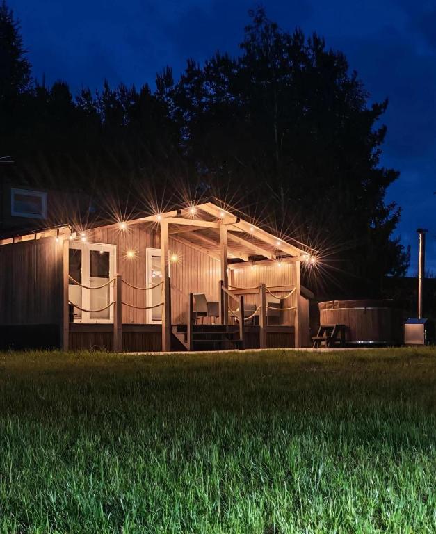 a house with lights on the side of it at night at Studniarskie Zacisze - domek Moringa in Borzechowo
