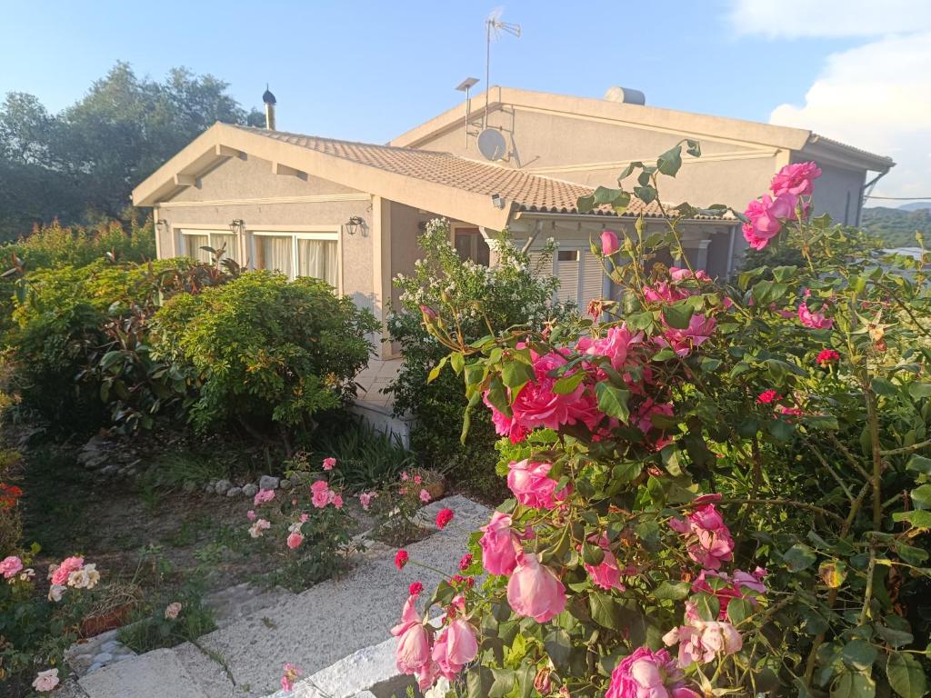 ein Haus mit rosa Blumen davor in der Unterkunft Villa Ewa in Págoi