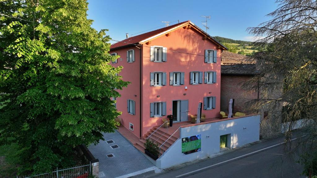 a large red building with stairs in front of a street at Ca' Lodola in Borzano