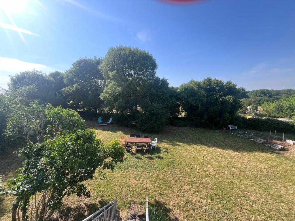 an open field with a picnic table and trees at Le Gîte de Saint Romans in Saint-Romans-lès-Melle