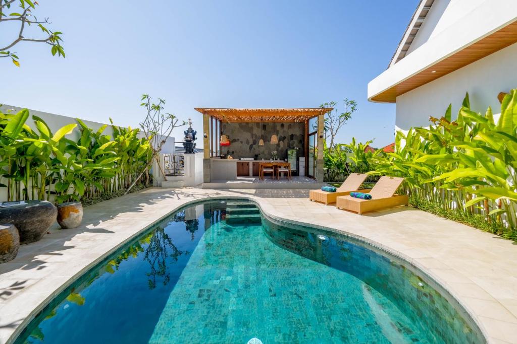 a swimming pool in the backyard of a house at Juna Guest House in Uluwatu