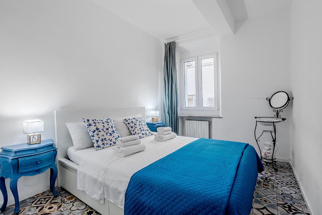 a bedroom with a blue and white bed and a window at Le Finestre Sul Borgo 1 in Parma