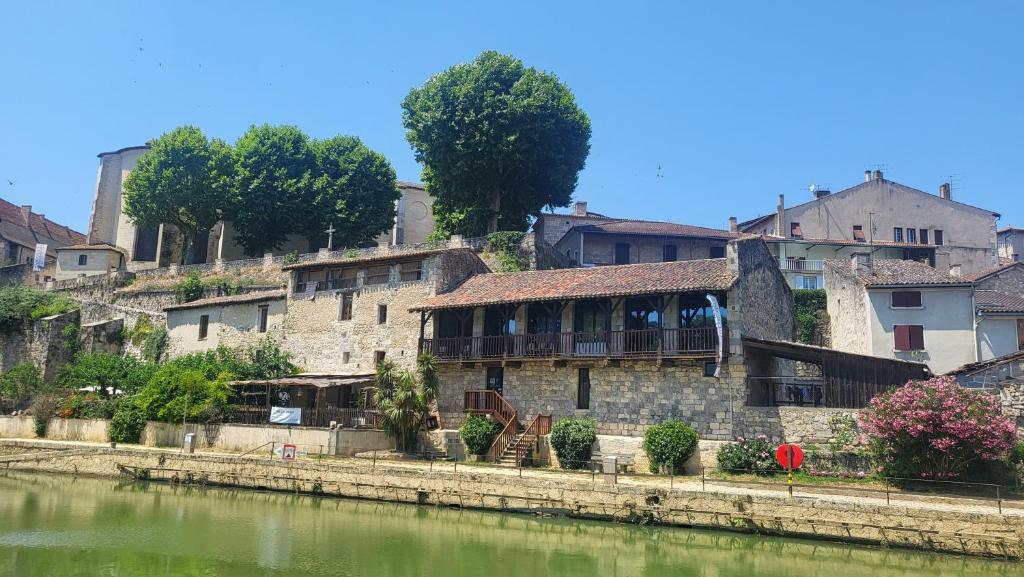 eine Gruppe von Gebäuden neben einem Fluss in der Unterkunft Le Sed' in Nérac