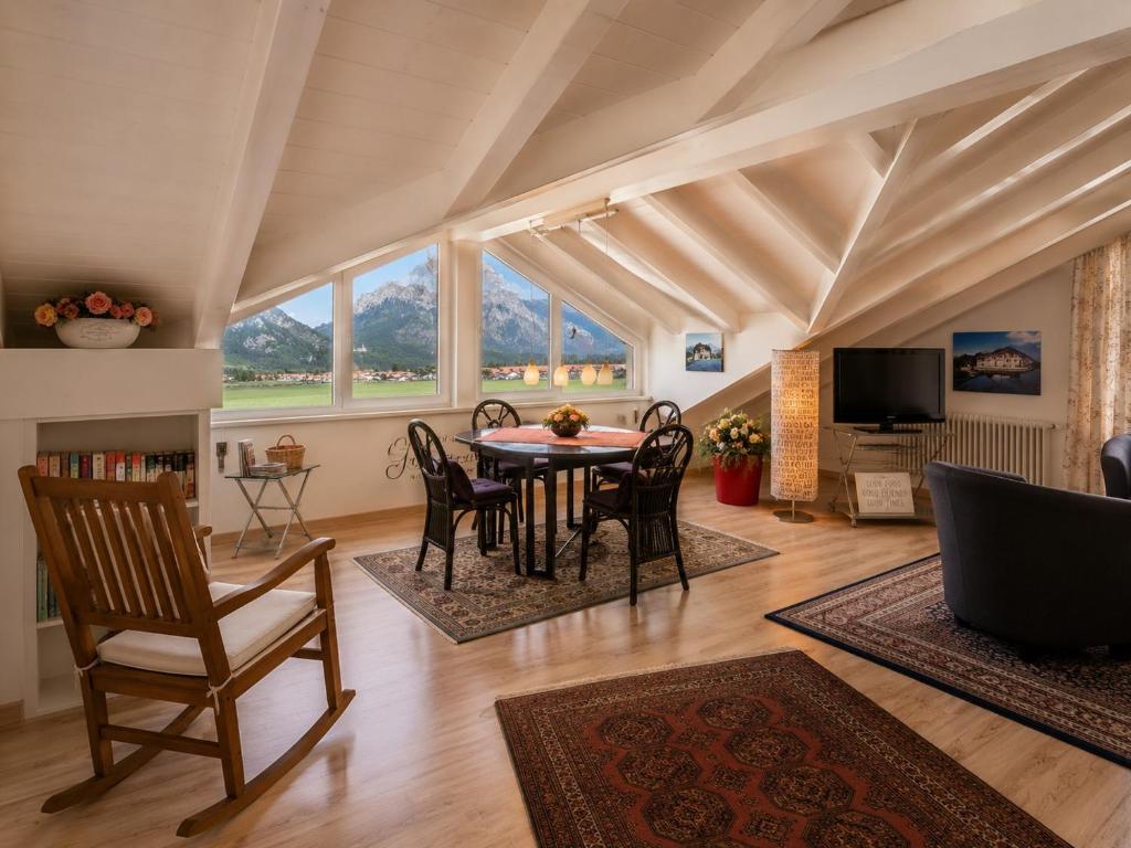 a living room with a table and chairs and a tv at Ferienwohnung Biechteler in Schwangau