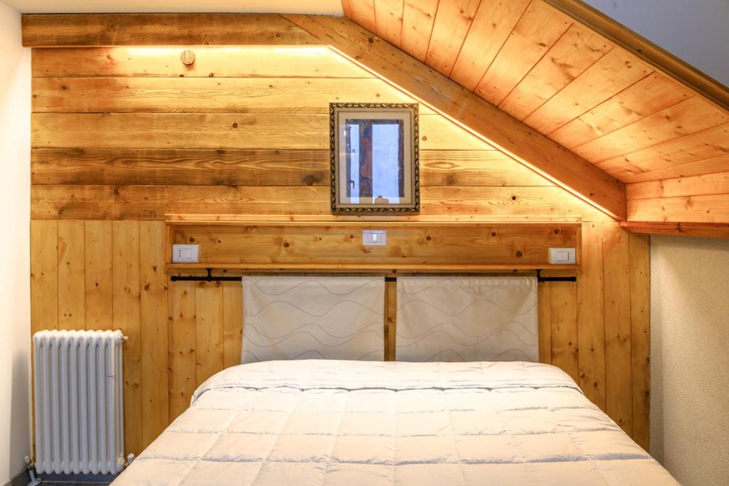 a bedroom in a tiny house with a roof at Mansarda al Lago Casa Lavaredo in Auronzo di Cadore