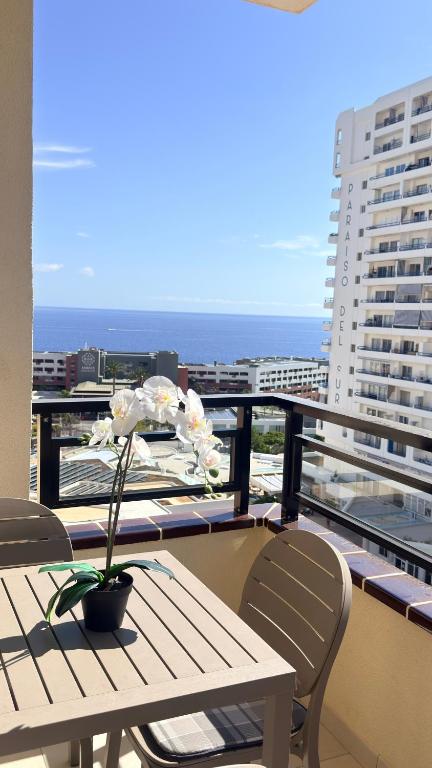 a table and chairs on a balcony with a view of the ocean at Cozy Ocean view 1 BDR APT, Club Paraiso in Playa Paraiso