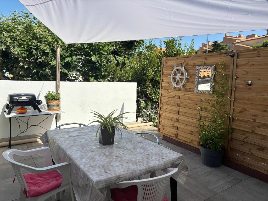 a table and chairs on a patio with an umbrella at My Pradet in Le Pradet