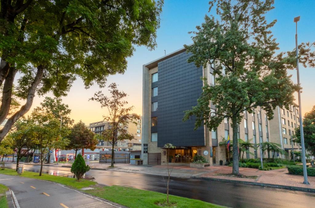 ein Gebäude an einer Straße mit Bäumen in der Unterkunft Hotel Morrison Usaquén in Bogotá