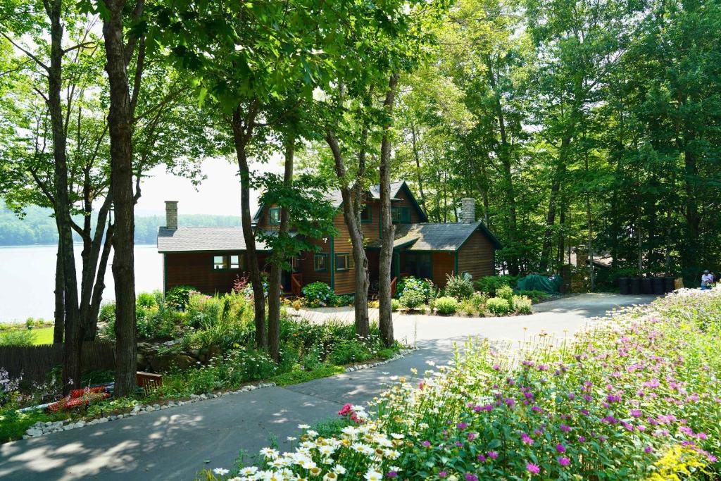 ein Haus inmitten eines Gartens mit Blumen in der Unterkunft Casco Cottage in Casco