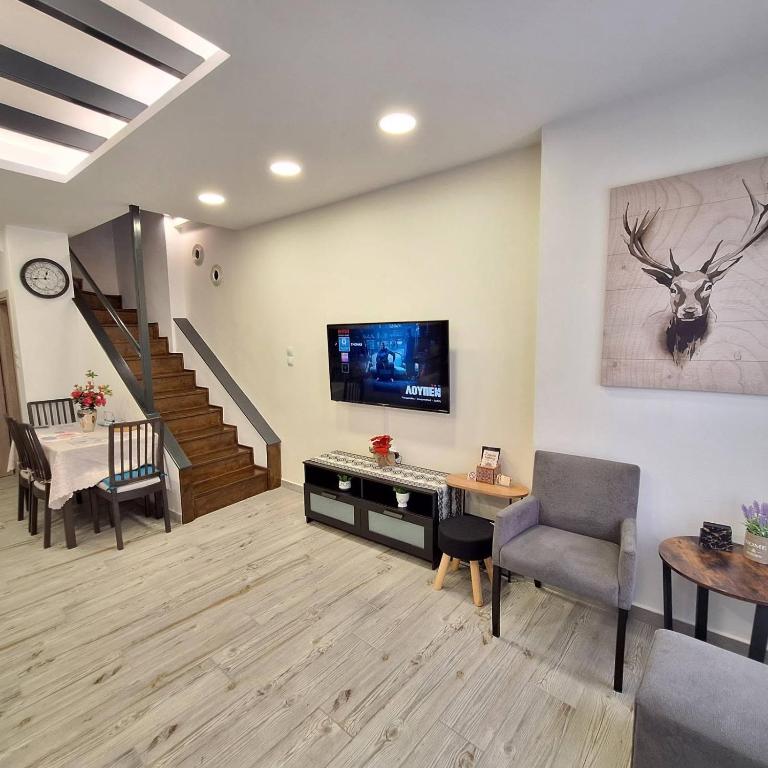 a living room with a tv and a staircase at THOMAS LUXURY MAISONETTE in the Historical Center of Ioannina in Ioannina