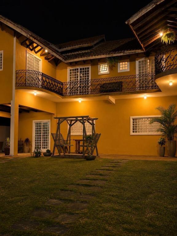 a house with a bench in the yard at night at Villa das Calliandras in Chapada dos Guimarães
